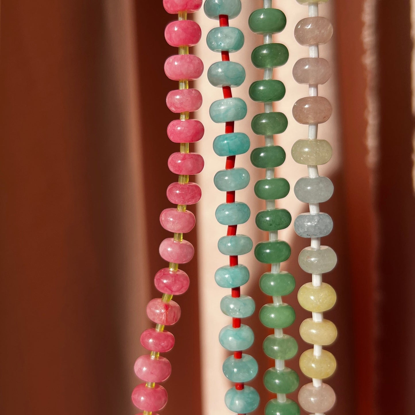 close- up of the whole collection of handbeaded necklace made using button shaped beads of  agate stones with tiny colorful glass beads. trending chunky beaded necklace for summer
