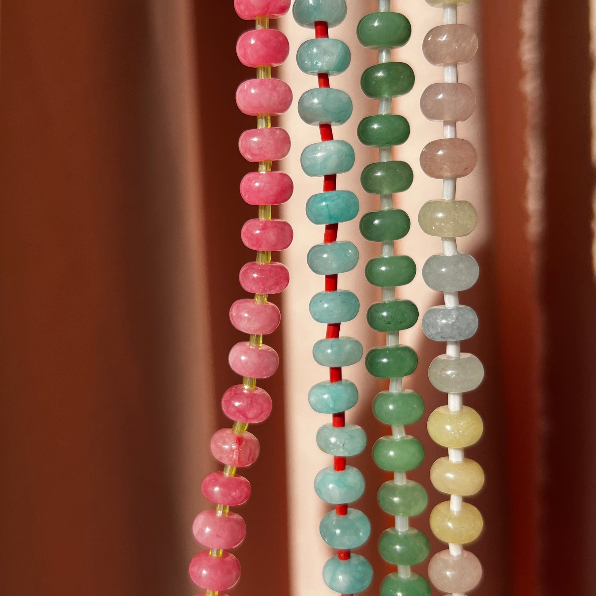 close- up of the whole collection of handbeaded necklace made using button shaped beads of  agate stones with tiny colorful glass beads. trending chunky beaded necklace for summer