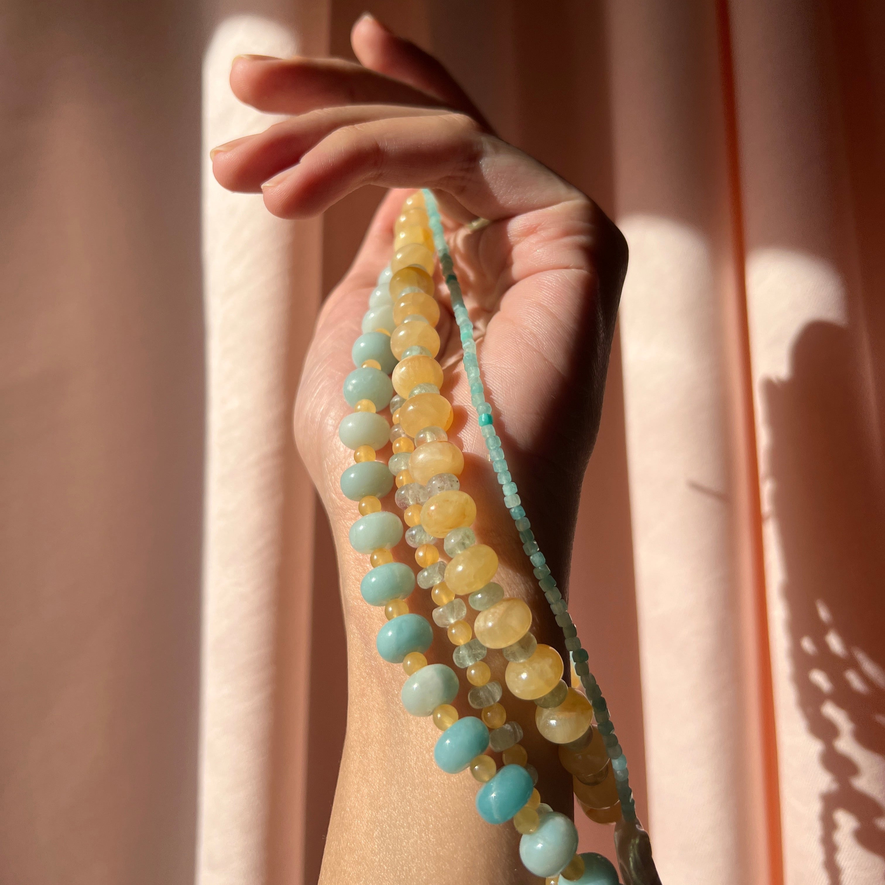 close-up shot of the hand-beaded Citrine Skies Necklace collection in butter yellow agate stones blue stones