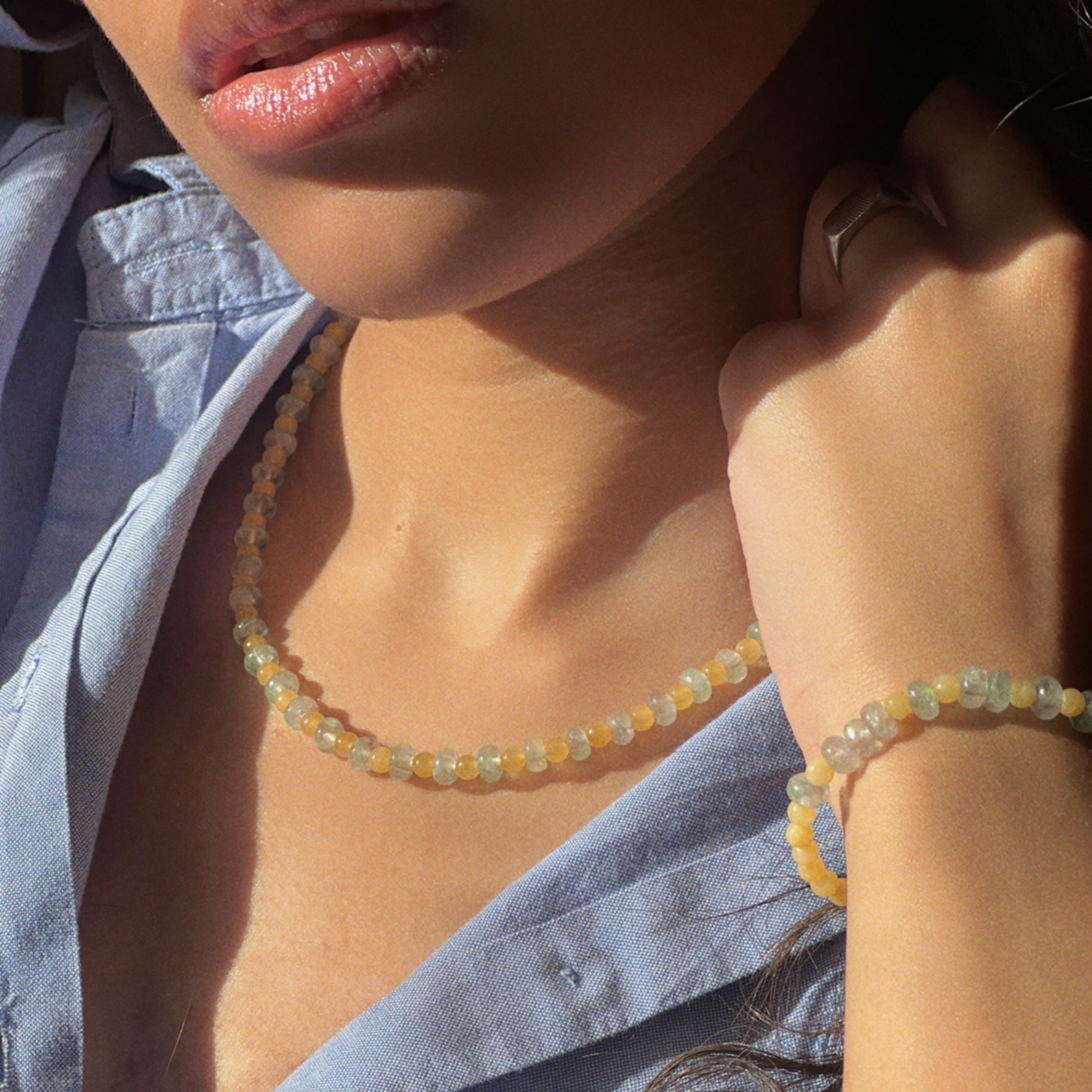 try-on shot of the hand-beaded Citrine Skies set of necklace and bracelet in butter yellow agate stones and tourmaline blue stones.
 A soft summer day, captured in stone.
Inspired by the golden warmth of citrine sunsets and the tranquility of clear skies. Blends butter yellow and sky blue tones in a dreamy, refreshing palette. Handcrafted with natural jade and  tourmaline  gemstones and finished with 925 sterling silver clasp.  Material: Natural jade stones - Length: 42 cm - 925 sterling silver clasp. 