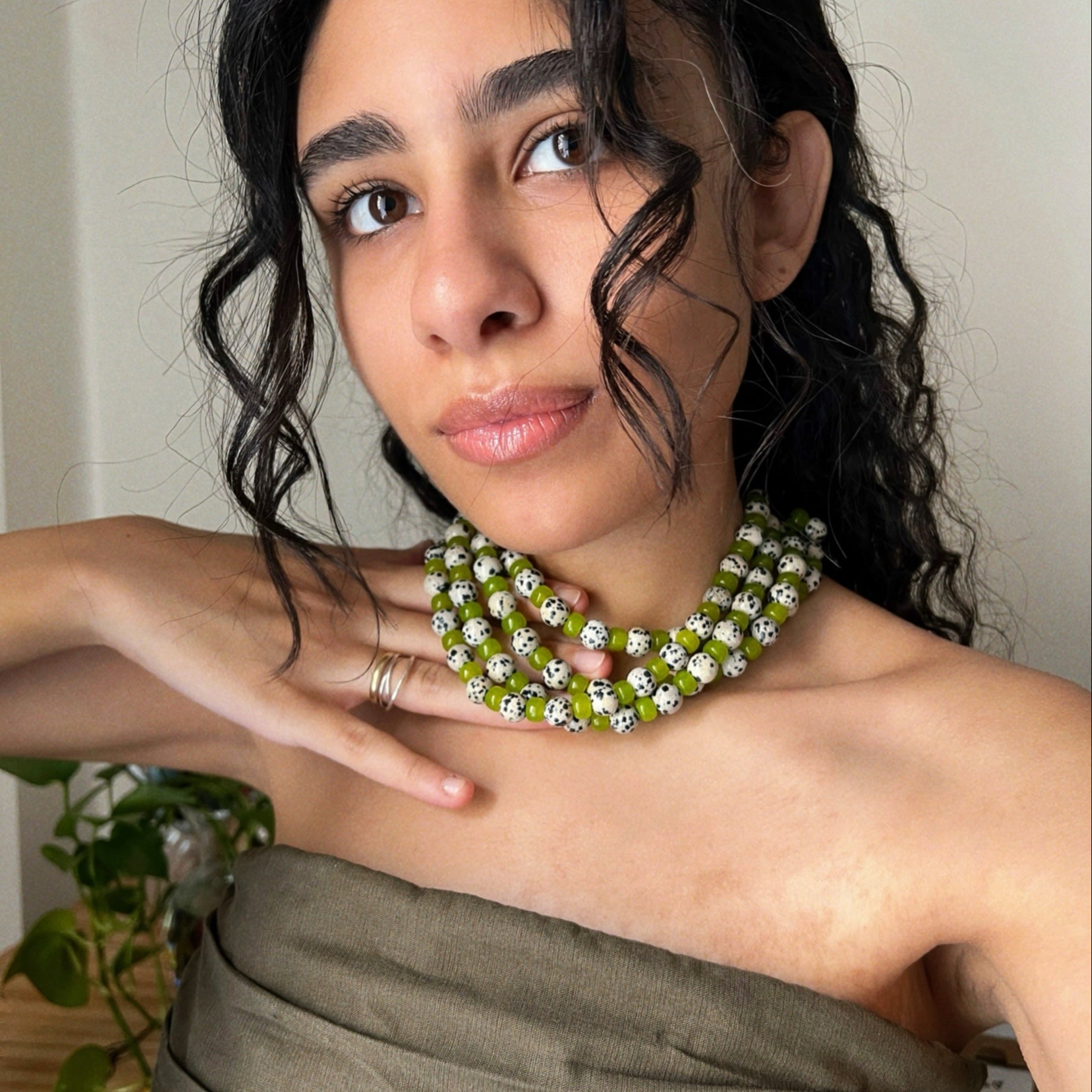wearing multiple green jade and dalmatian jasper beaded necklaces inspired from the character "cruella"