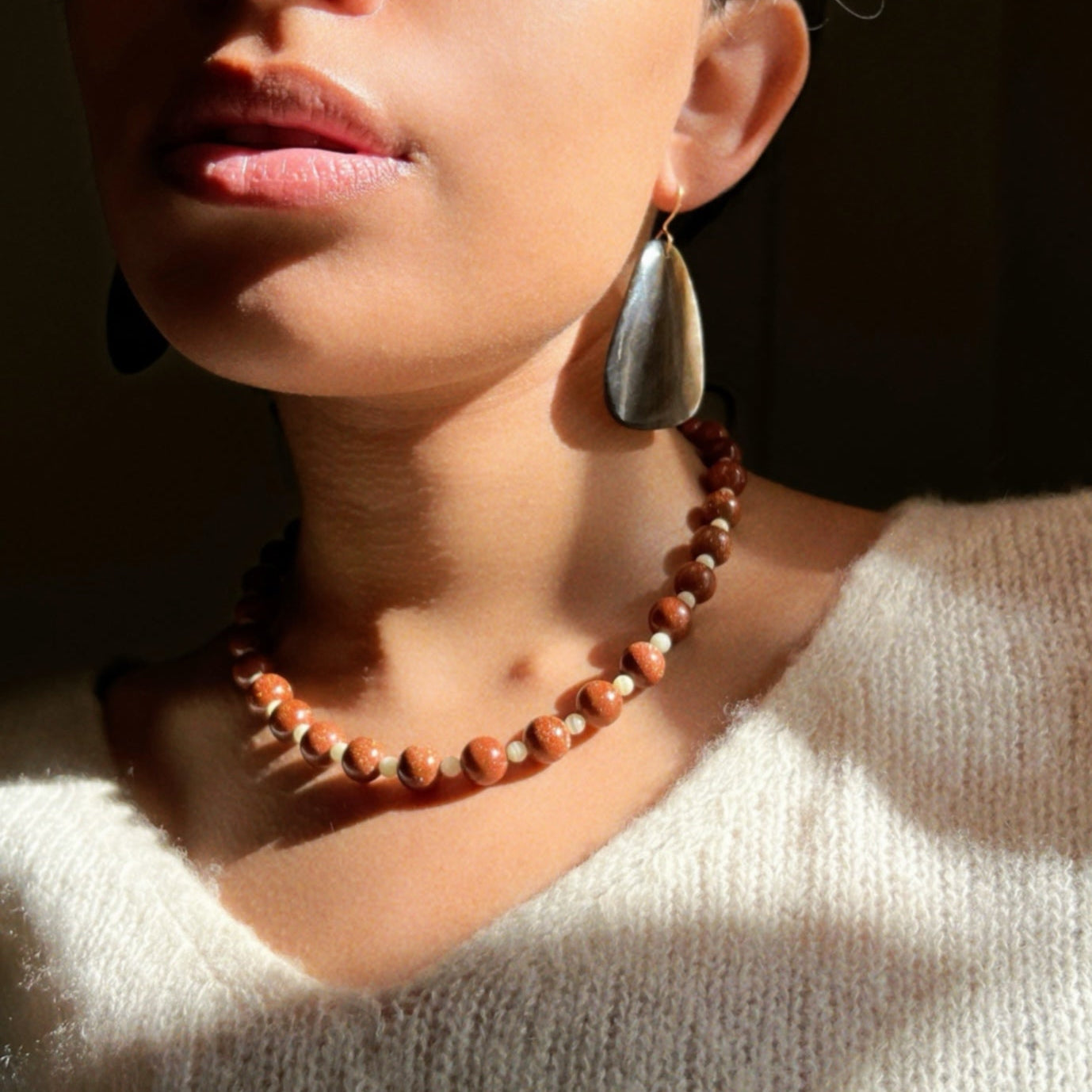 Hand-strung necklace with round golden brown sunstones and small mint green Jade stones. 