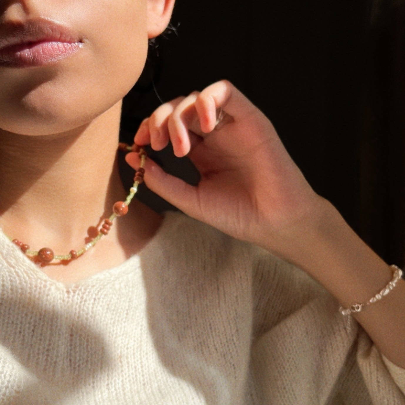 Hand-strung necklace with a mix of round and button shaped golden brown sunstones and green tiny peridot stones