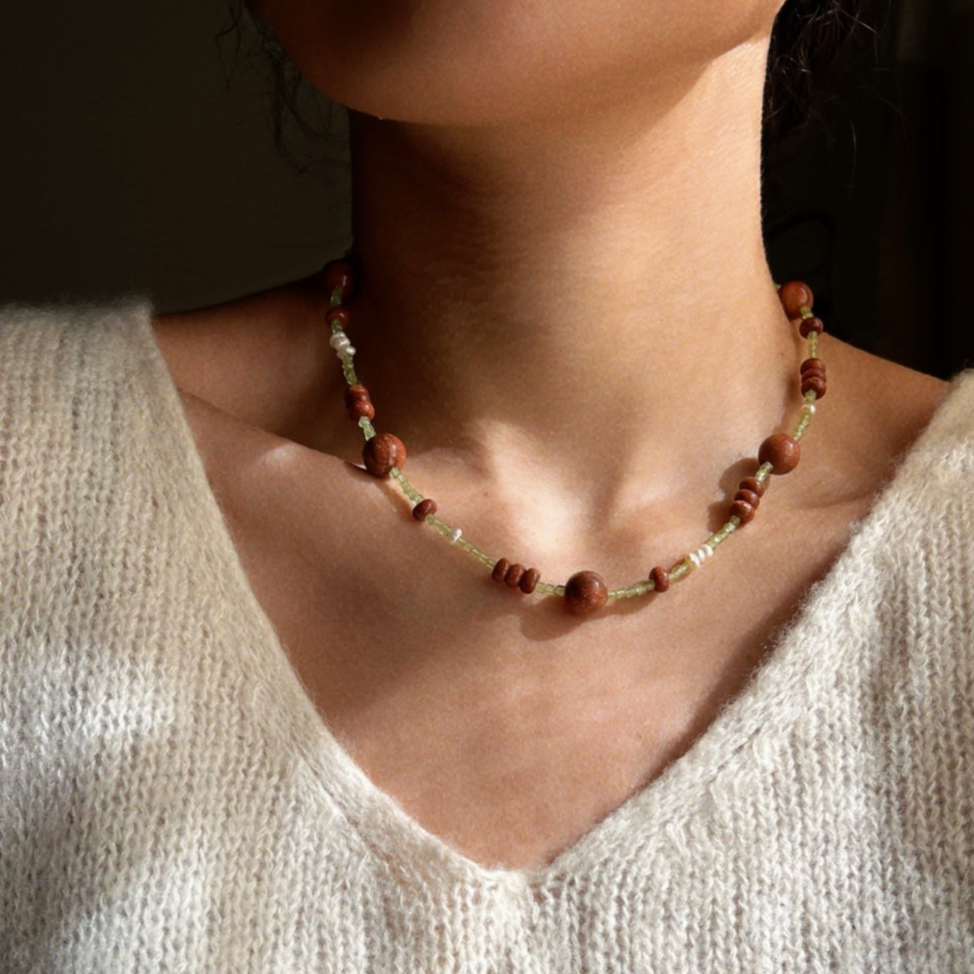 Hand-strung necklace with a mix of round and button shaped golden brown sunstones and green tiny peridot  stones