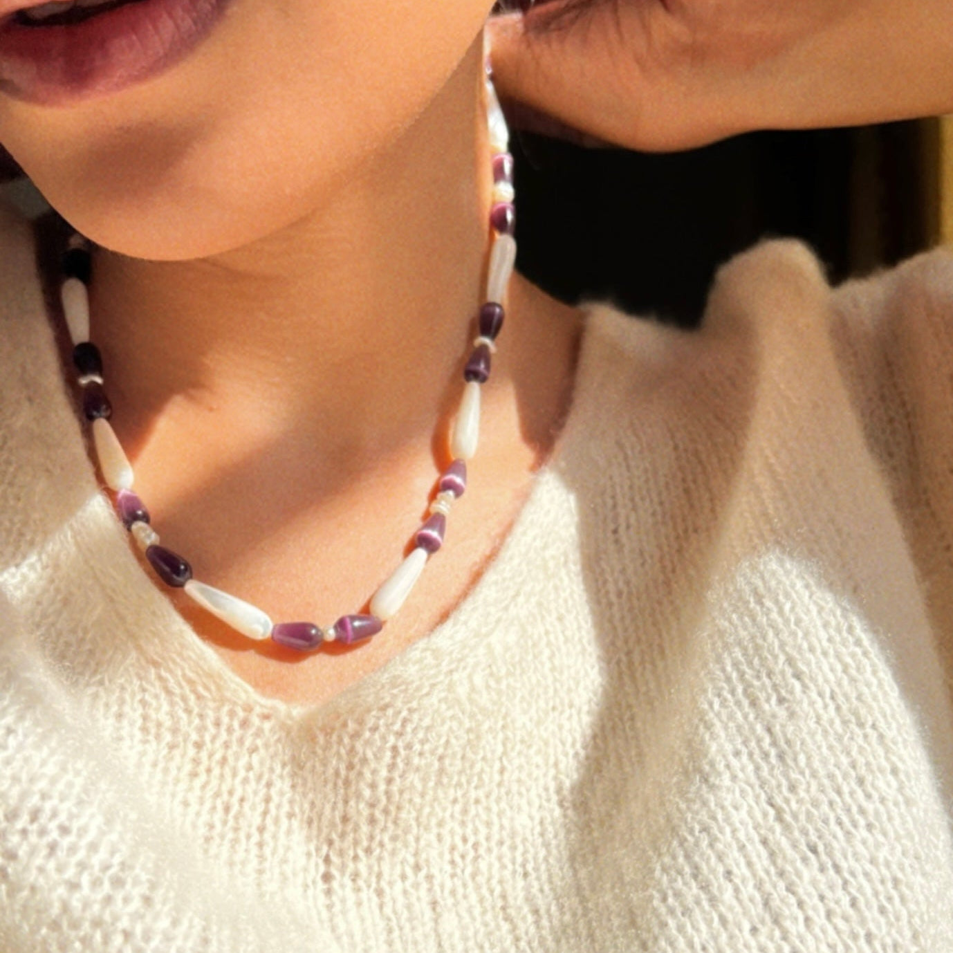 Hand-strung necklace with purple cat's eye stones and white mother of pearls beads.