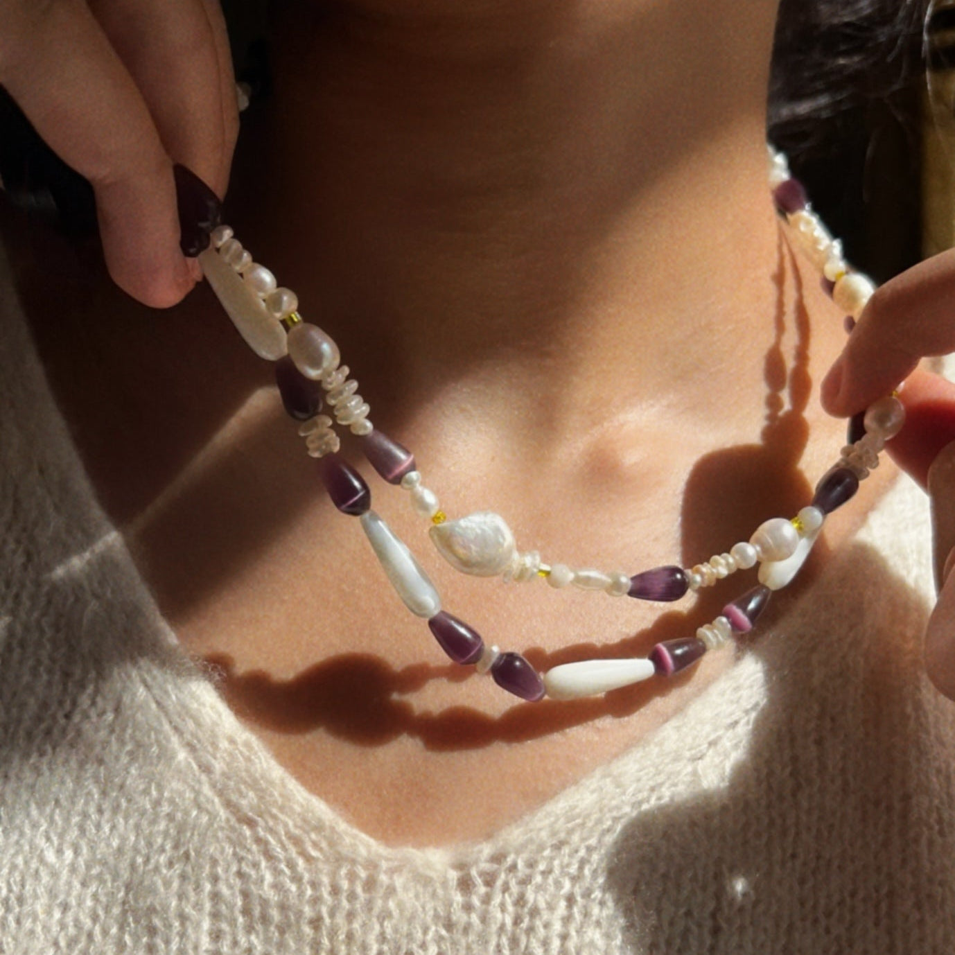 Two layers of Hand-strung necklace with purple cat's eye stones and white mother of pearls beads, natural white pearls and yellow glass beads.