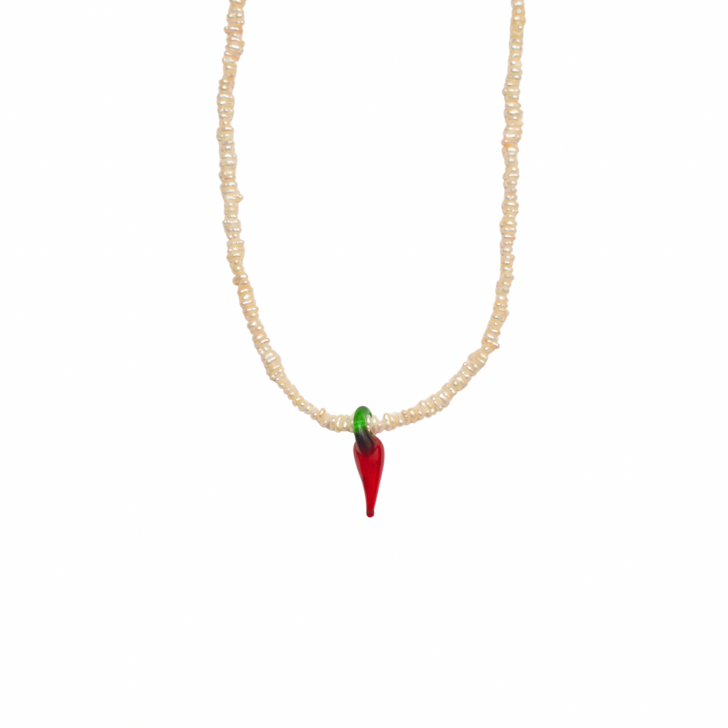 Necklace with natural white pearls a glass chili pendant on white background