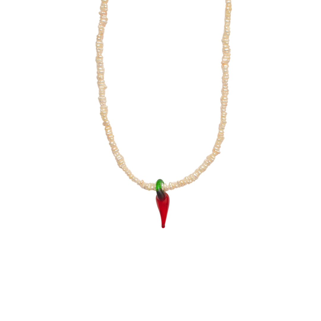 Necklace with natural white pearls a glass chili pendant on white background